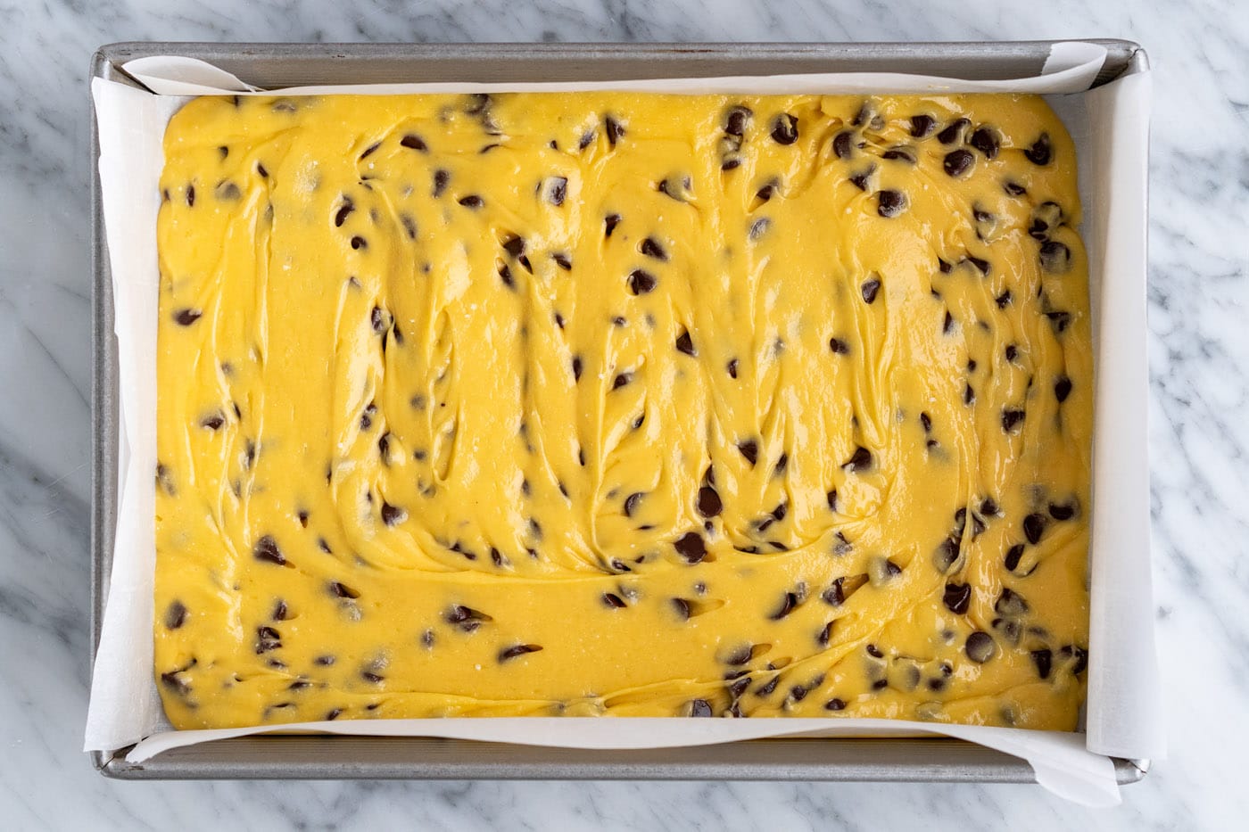 cake mix cookie bar batter spread out in a baking pan