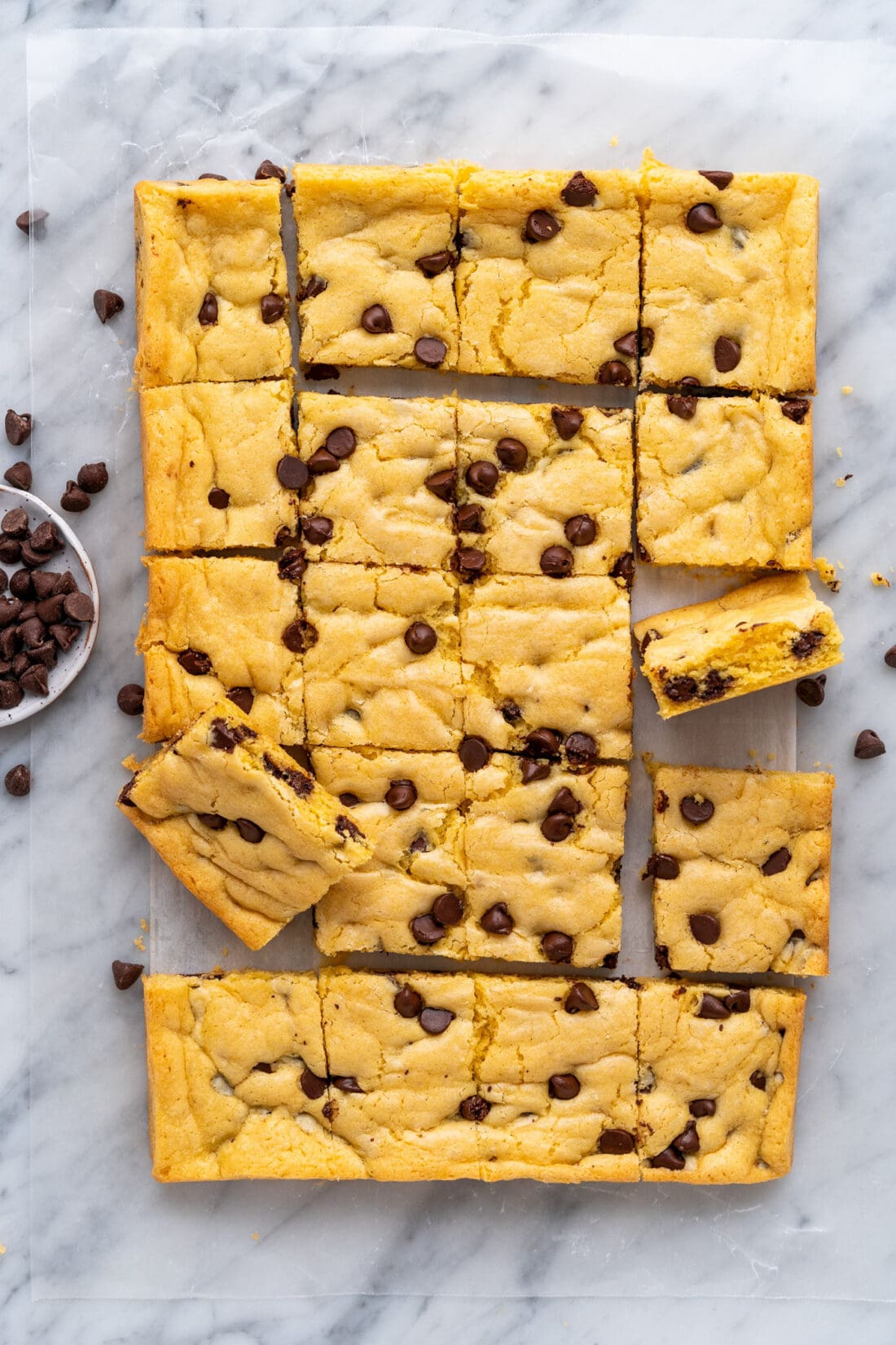 Sheet of Cake Mix Cookie Bars cut up into squares on parchment paper