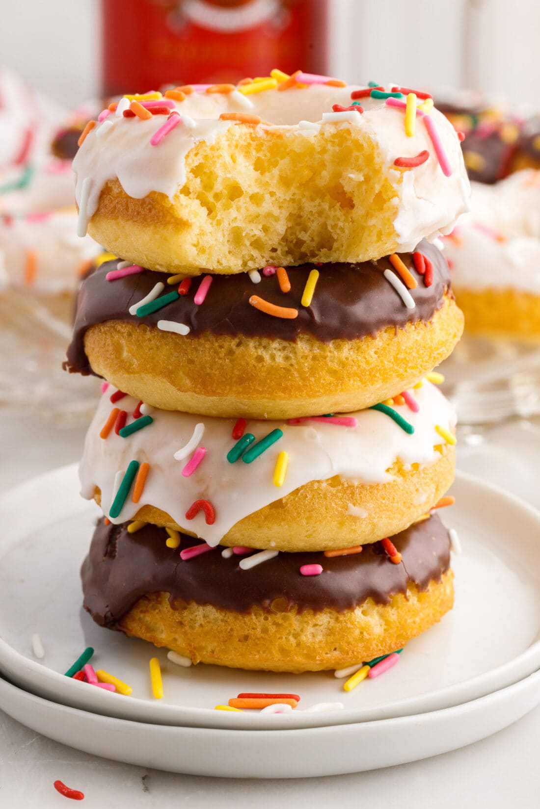 Cake Mix Donut with a bite taken out sitting on top of a stack of three Cake Mix Donuts