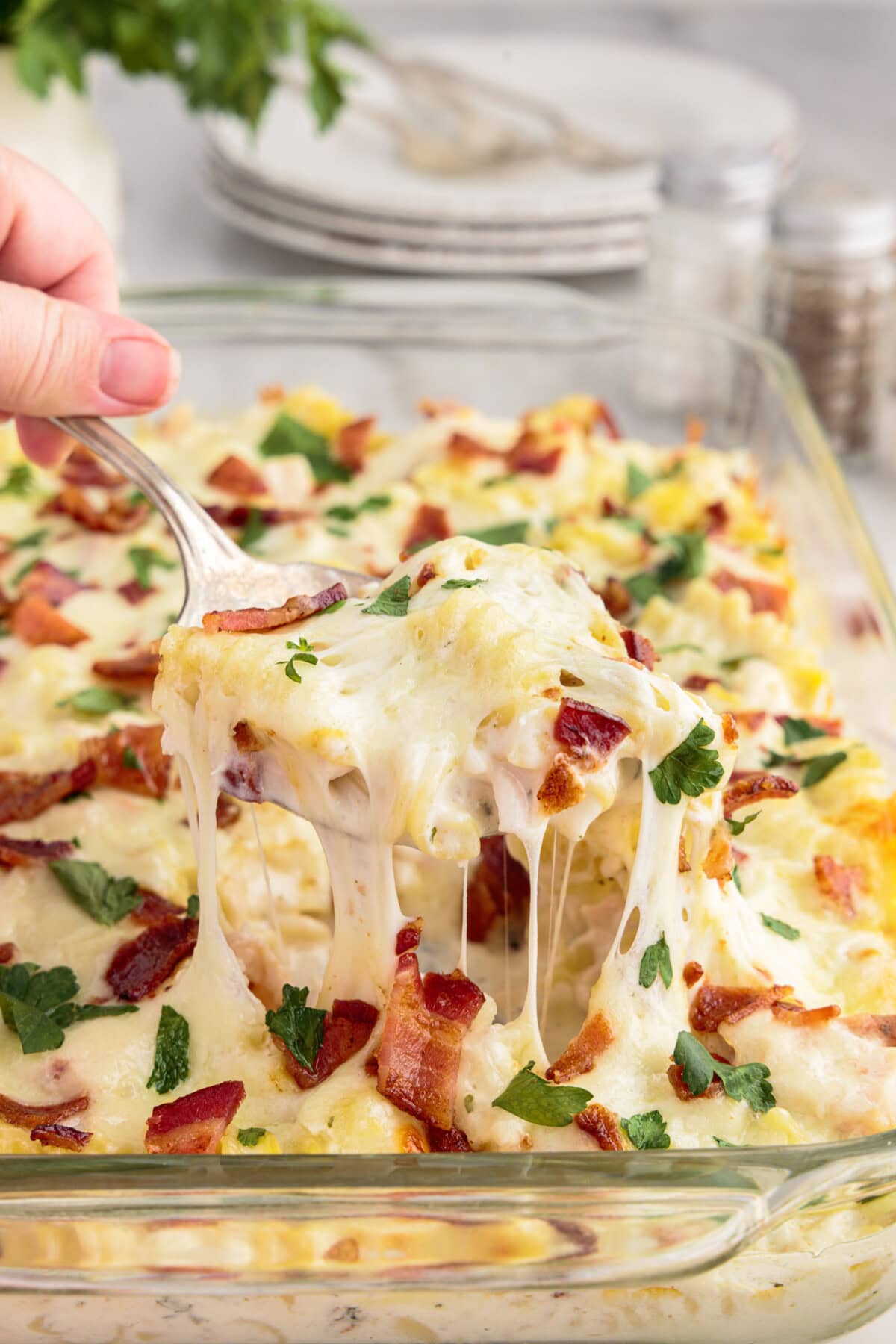 Spoonful of Chicken Bacon Ranch Casserole being lifted out of the casserole dish of Chicken Bacon Ranch Casserole