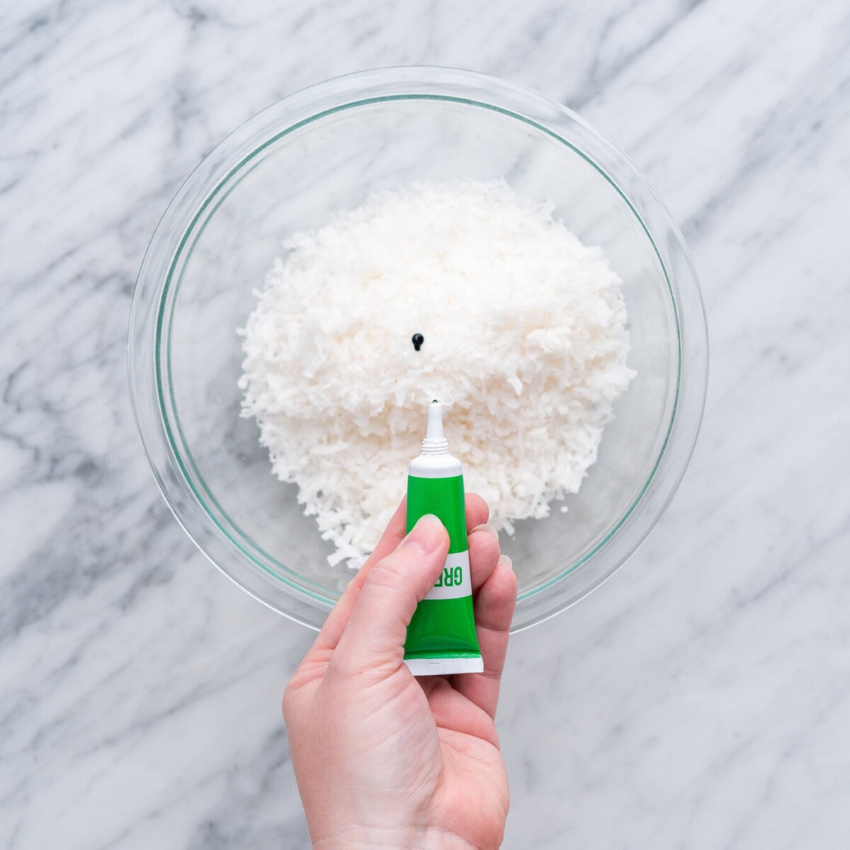 adding green gel food color to shredded coconut