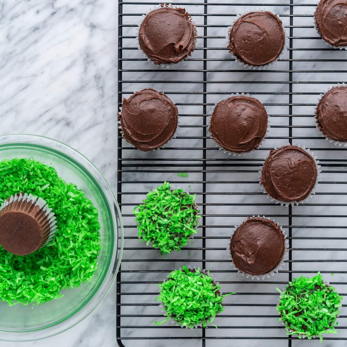 dipping cupcakes into shredded coconut