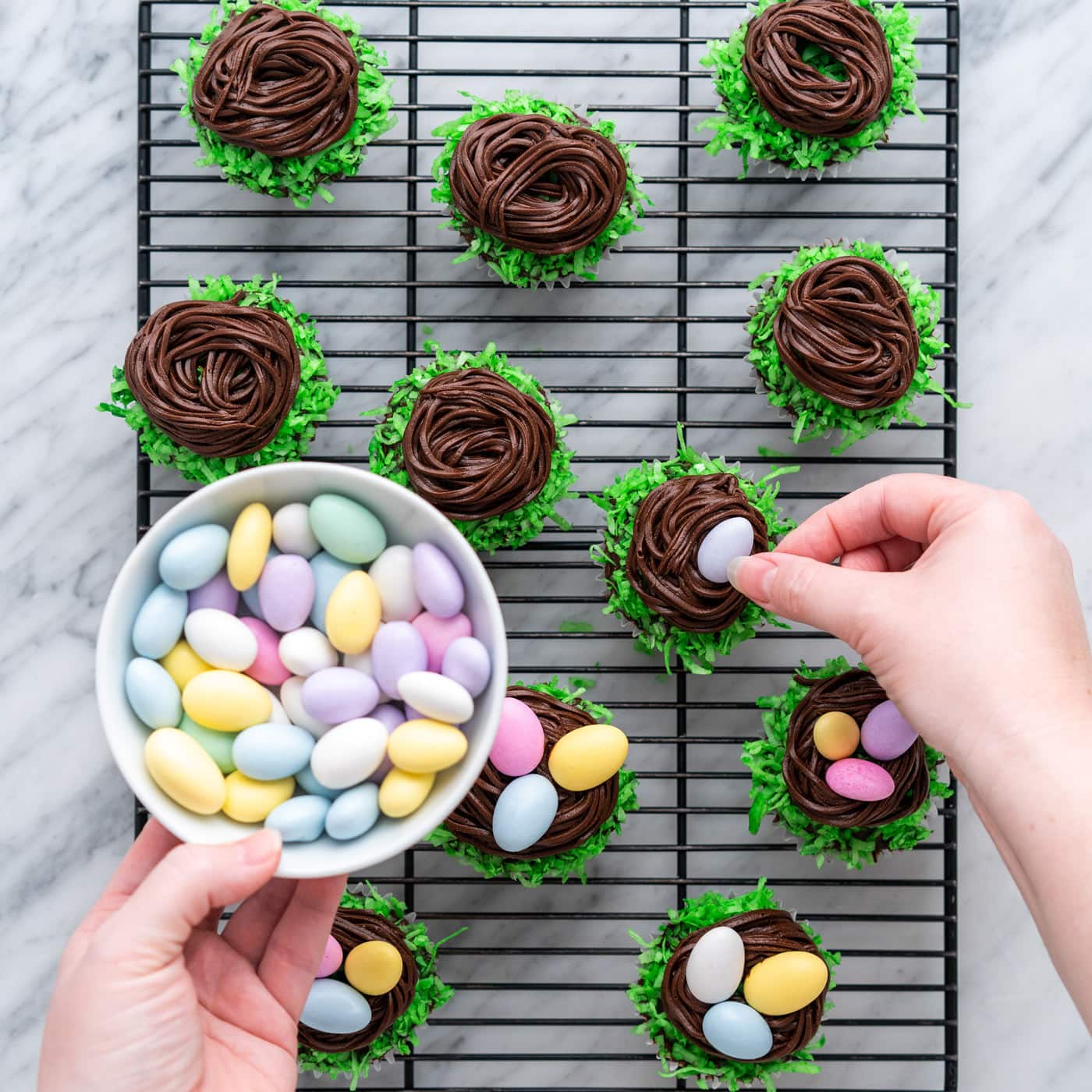 adding chocolate egg candy to easter nest cupcakes