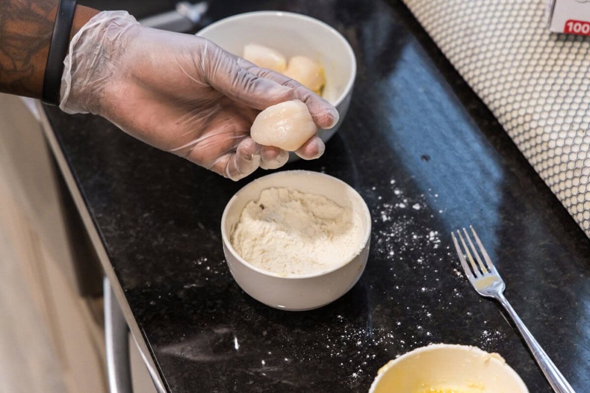 dipping scallop into flour