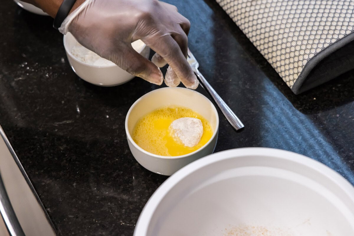 dipping floured scallop in egg