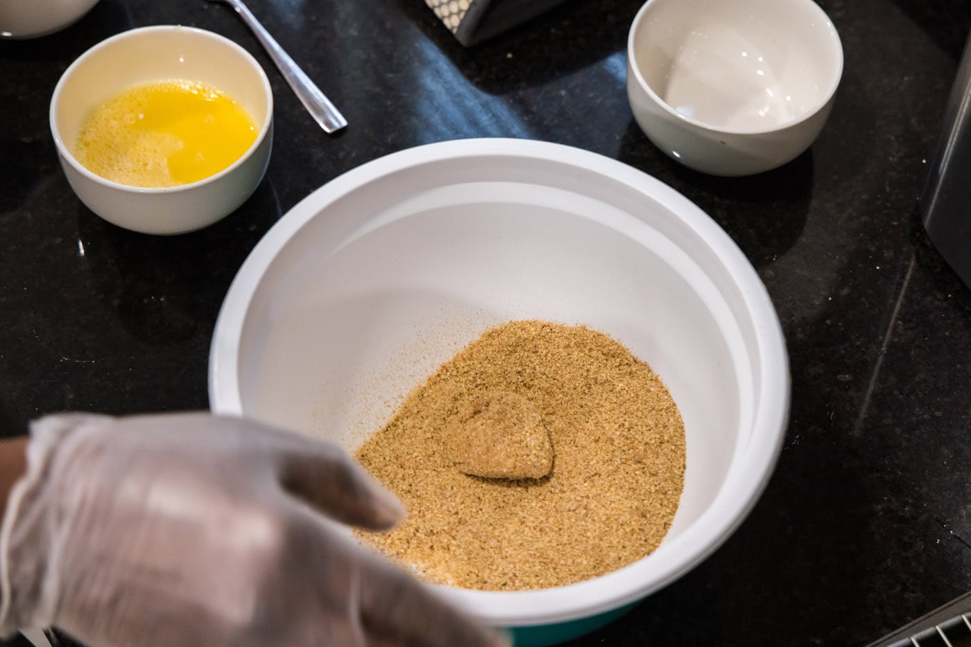 coating flour dredged scallop in breadcrumb mixture