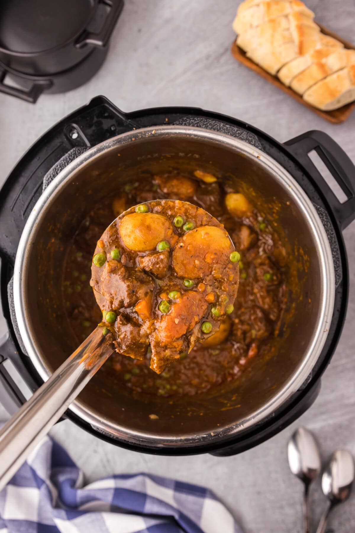 Ladle of Instant Pot Beef Stew being lifted out of an Instant Pot