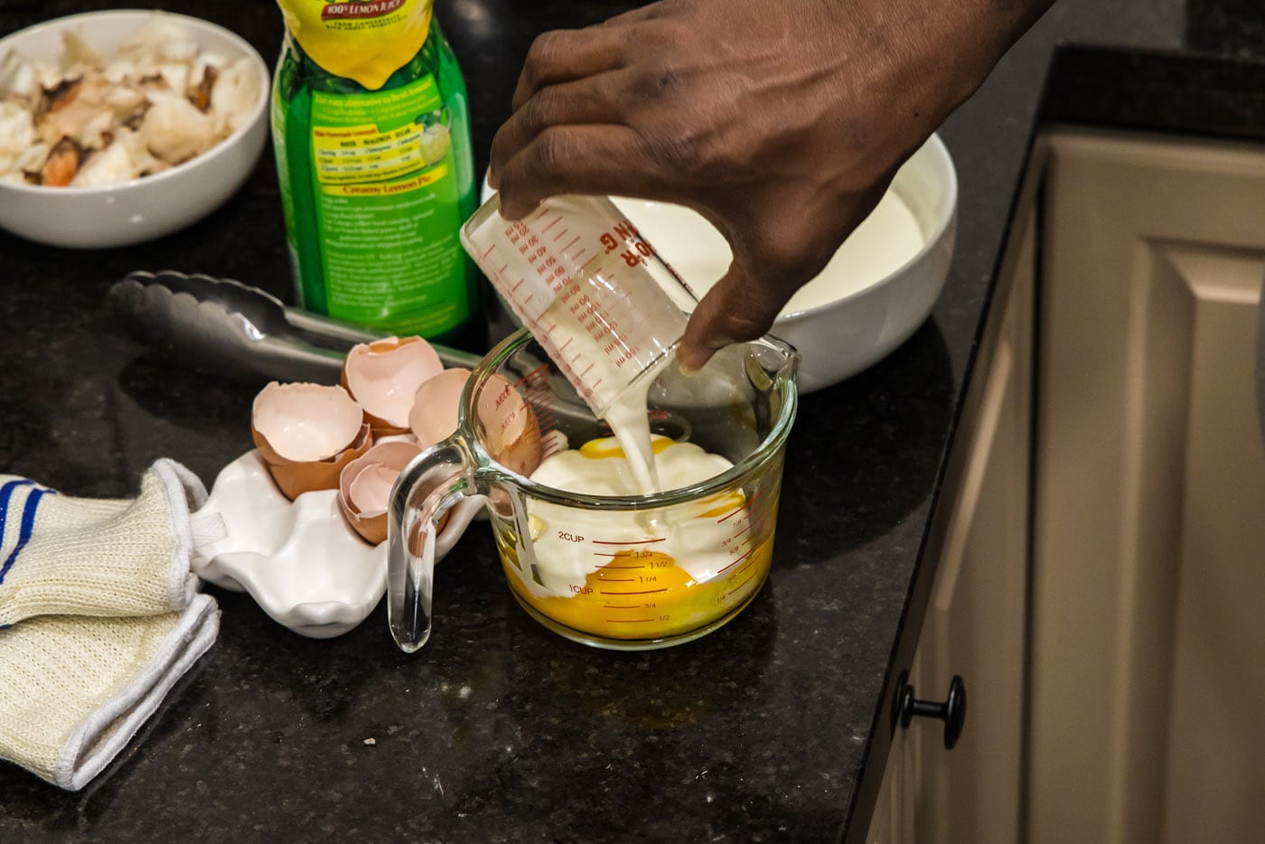 pouring heavy cream into eggs in a measuring cup