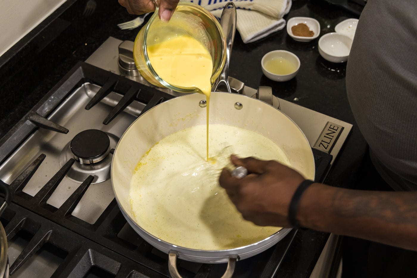 tempering egg mixture in a pan with cream