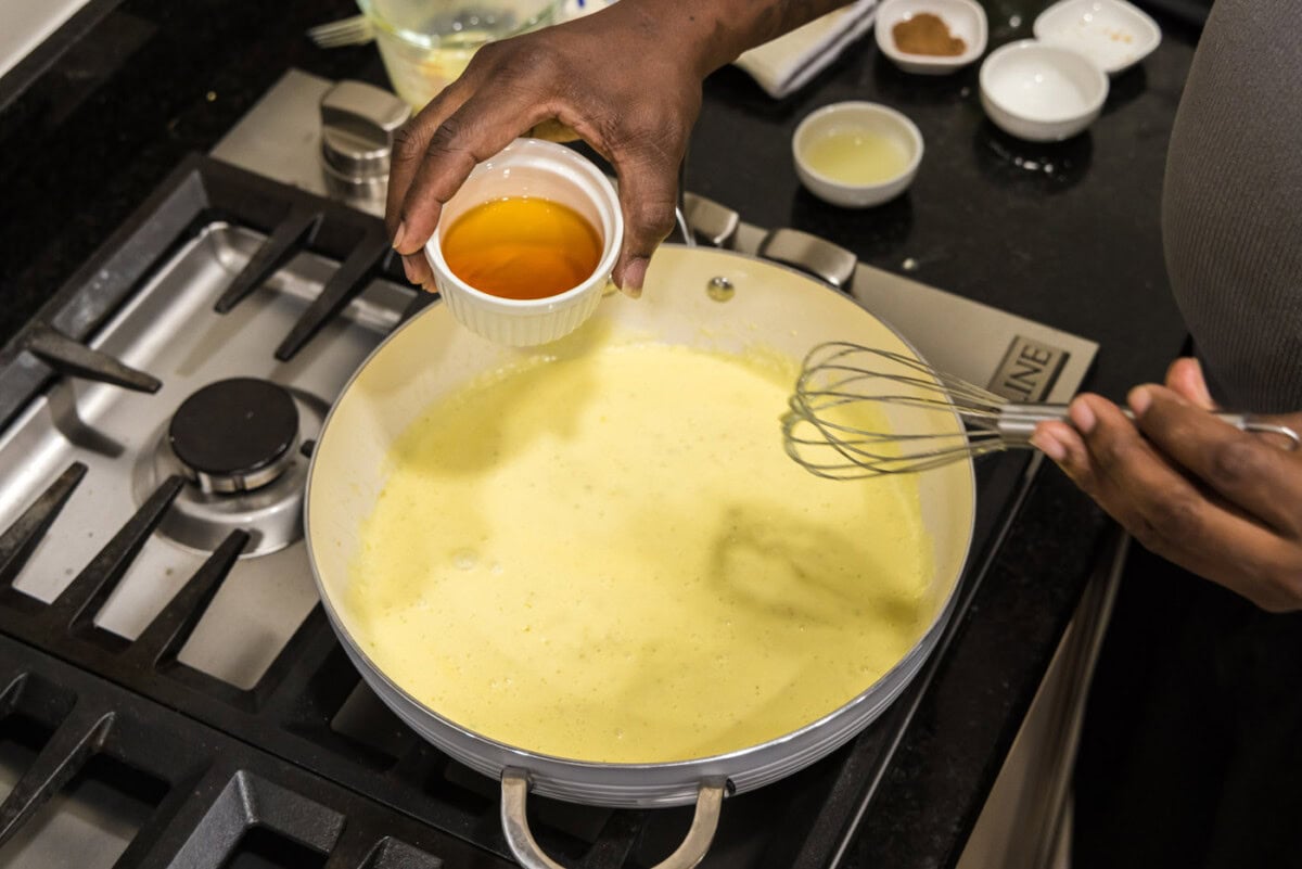 adding cognac to skillet with cream sauce