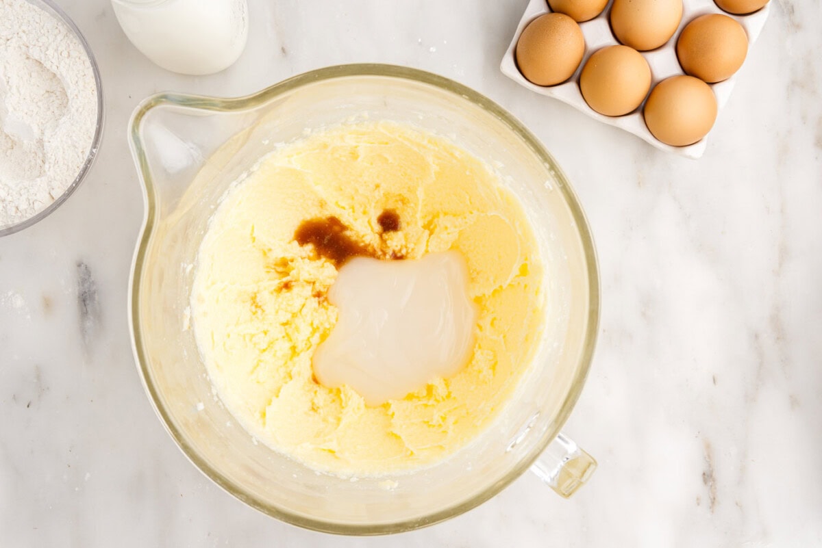 adding vanilla extract, coconut extract, and cream of coconut to cake mixture