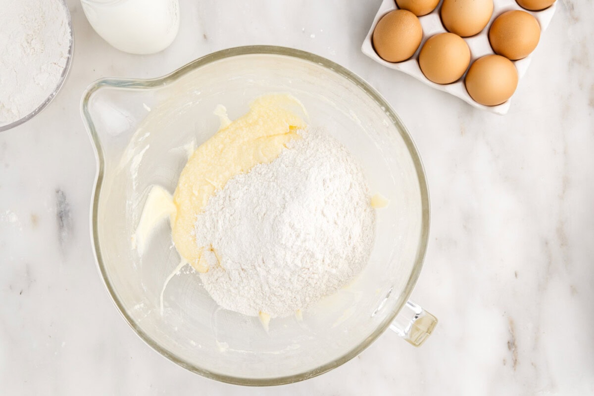 adding dry ingredients to wet ingredients for cake in a bowl