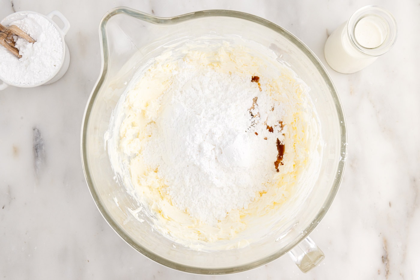 adding powdered sugar and vanilla to cream cheese frosting