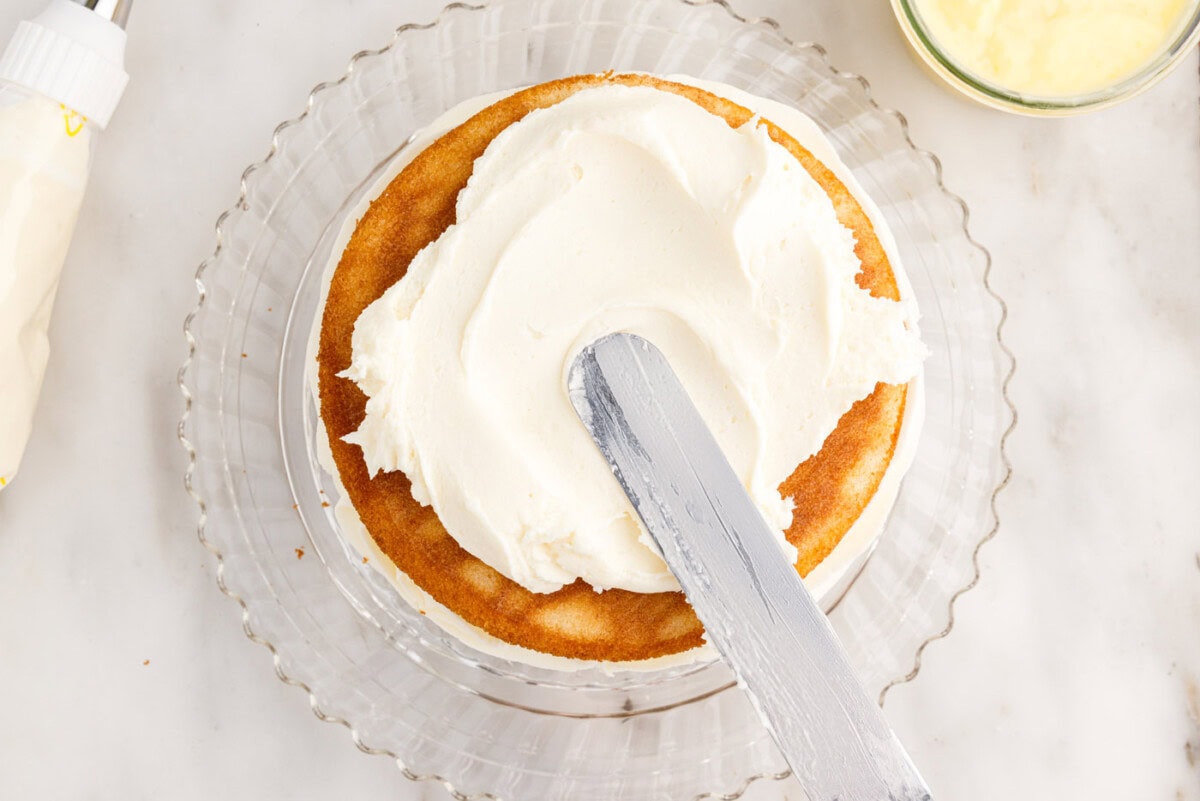spreading frosting on cake