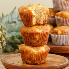 A Pineapple Muffin with a bite taken out stacked on top of two more Pineapple Muffins