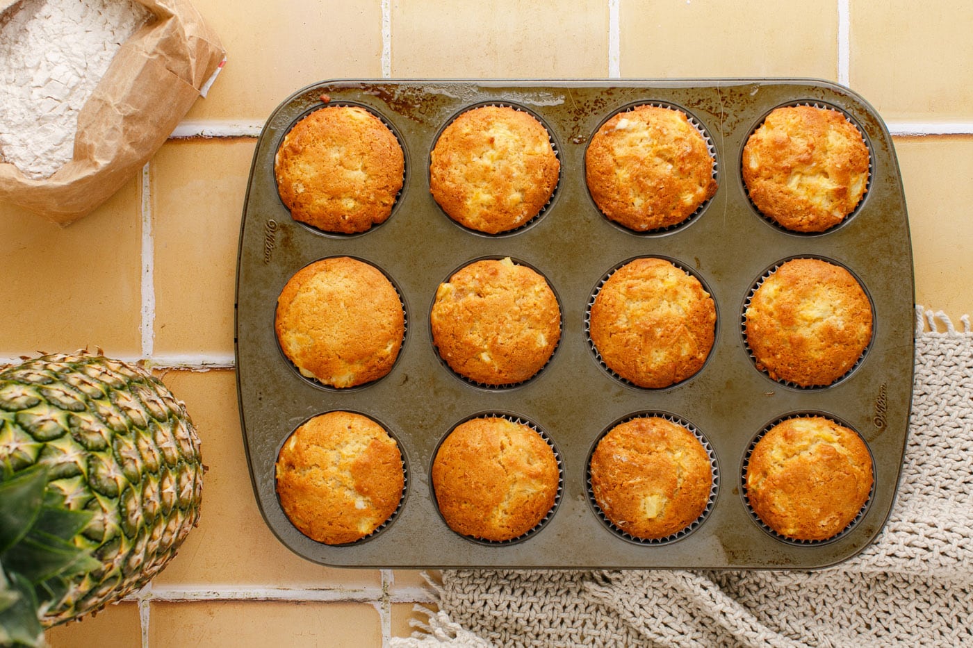 baked pineapple muffins in a muffin pan