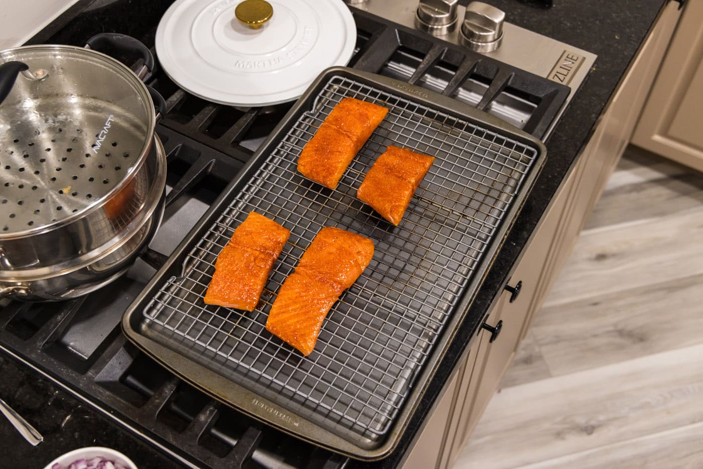 four salmon filets on a wire rack over a baking sheet