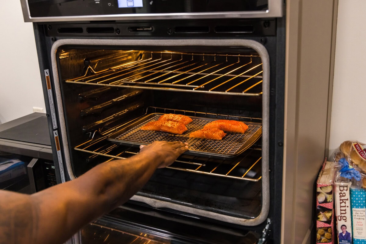 placing salmon filets in oven to roast
