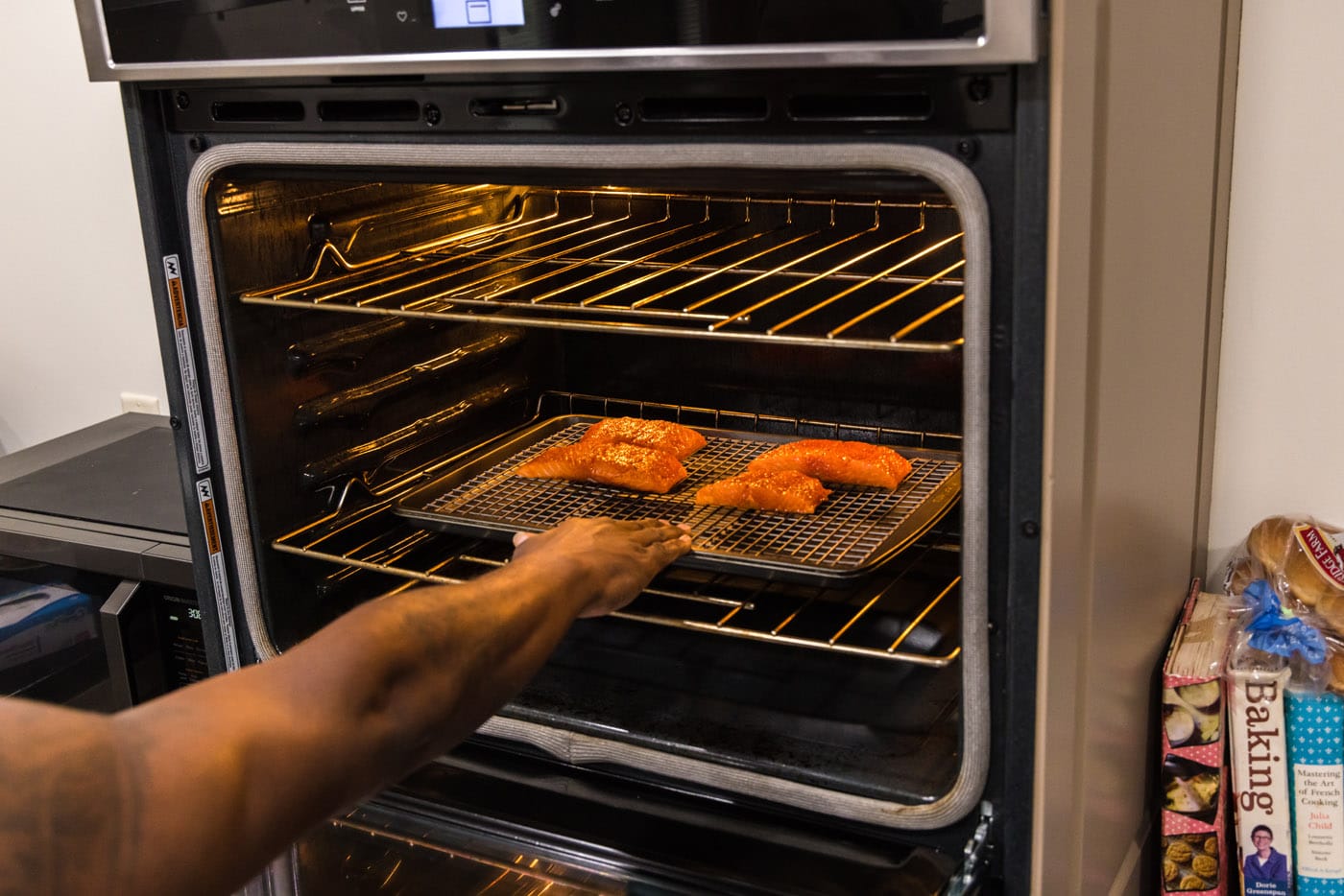 placing salmon filets in oven to roast