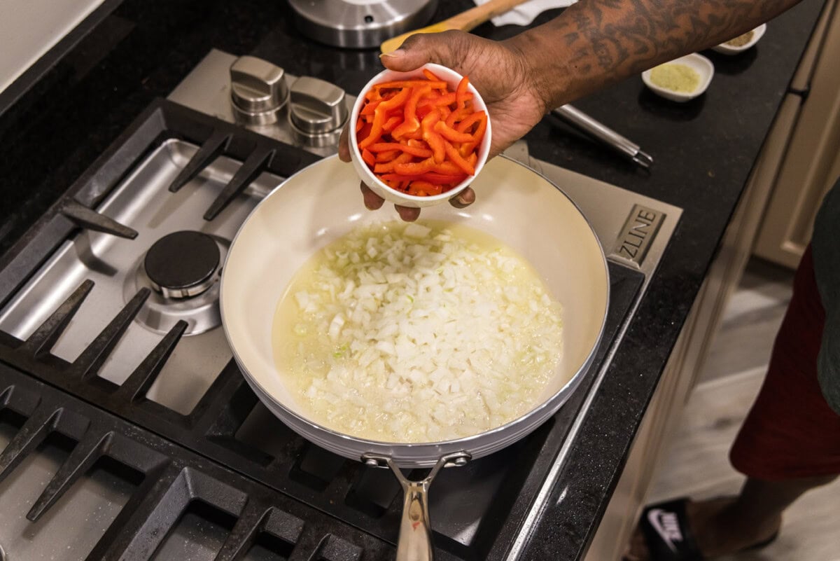 adding onion and bell pepper to skillet