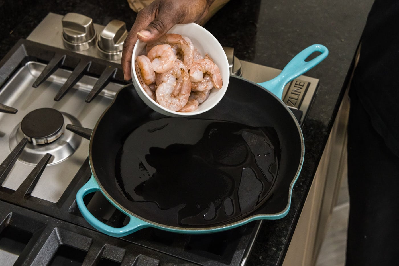 adding shrimp to skillet with oil