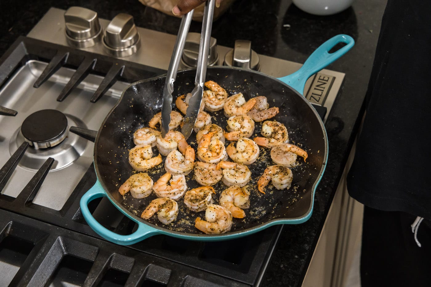 turning shrimp in a skillet with tongs