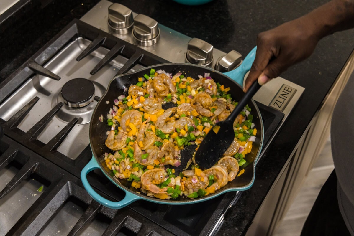 stirring shrimp quesadilla ingredients in a skillet