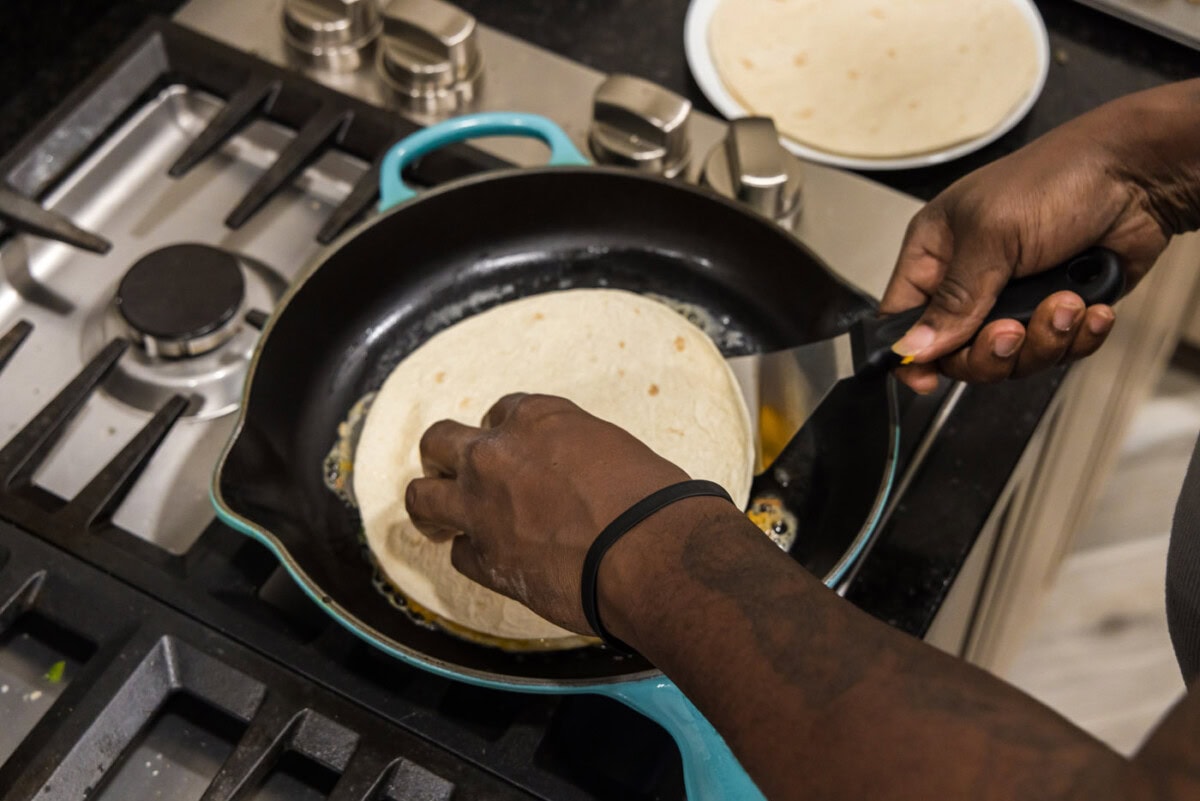 flipping shrimp quesadilla in a skillet