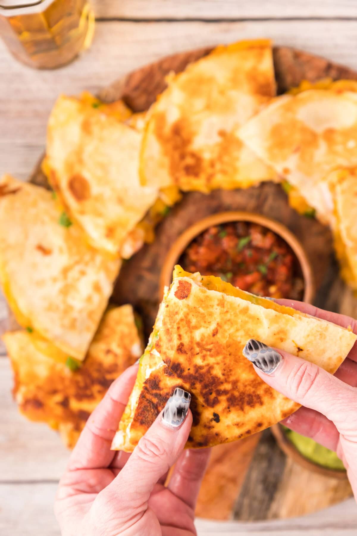 Hand holding a Shrimp Quesadilla triangle