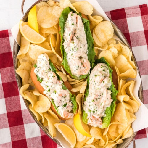 Three Shrimp Rolls in a serving tray with potato chips