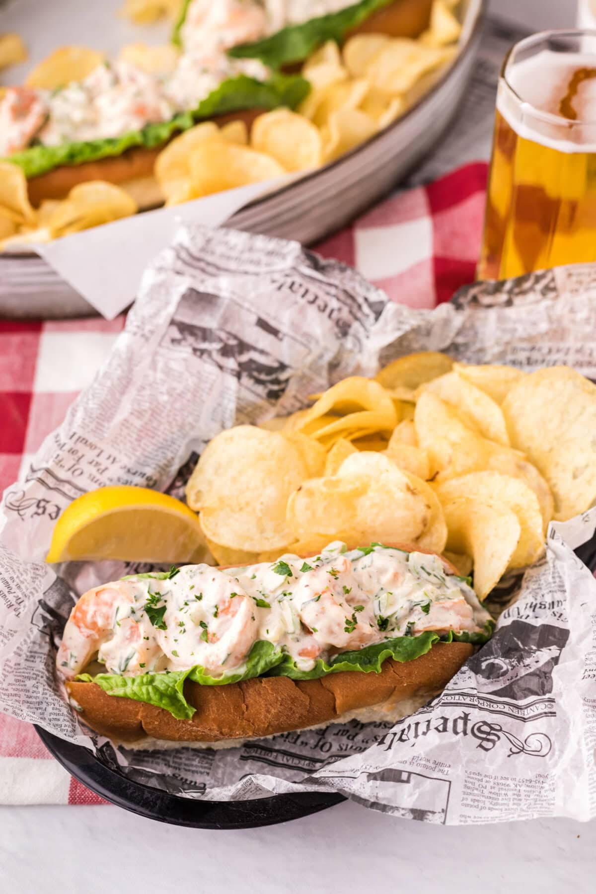 Shrimp Roll In a basket with potato chips and a lemon wedge