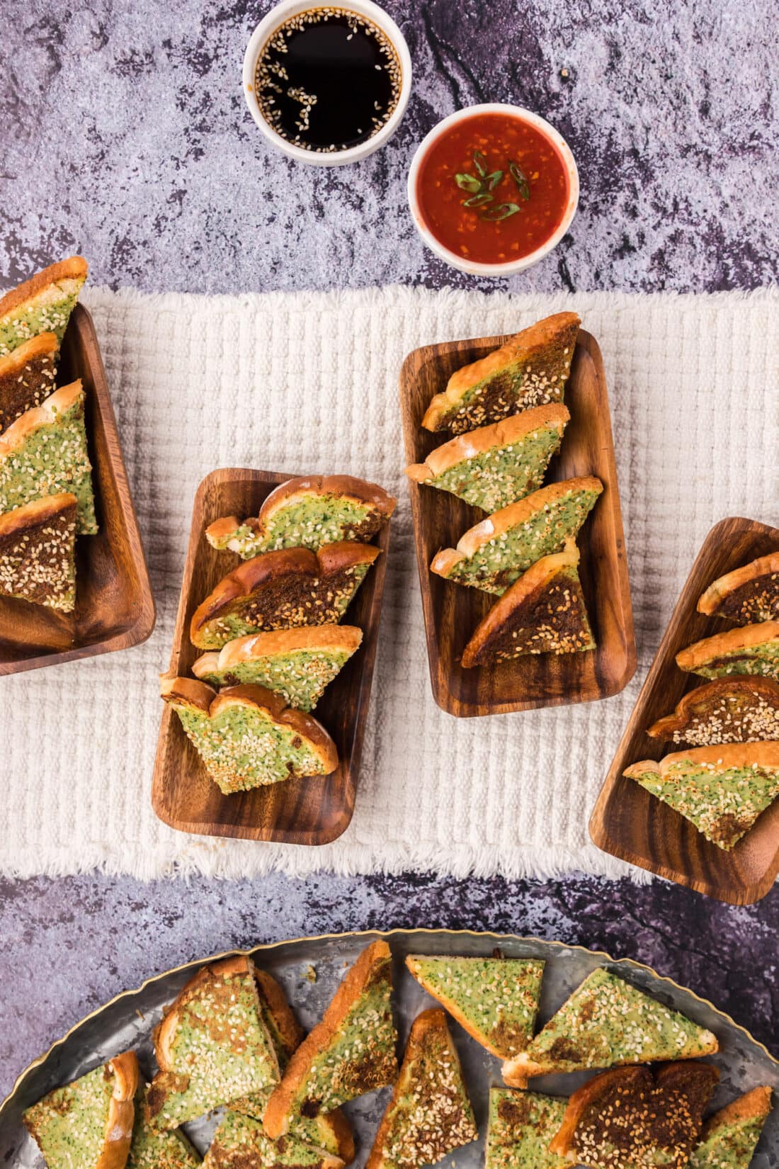 Shrimp Toast served on wooden serving plates with dipping sauces on the side