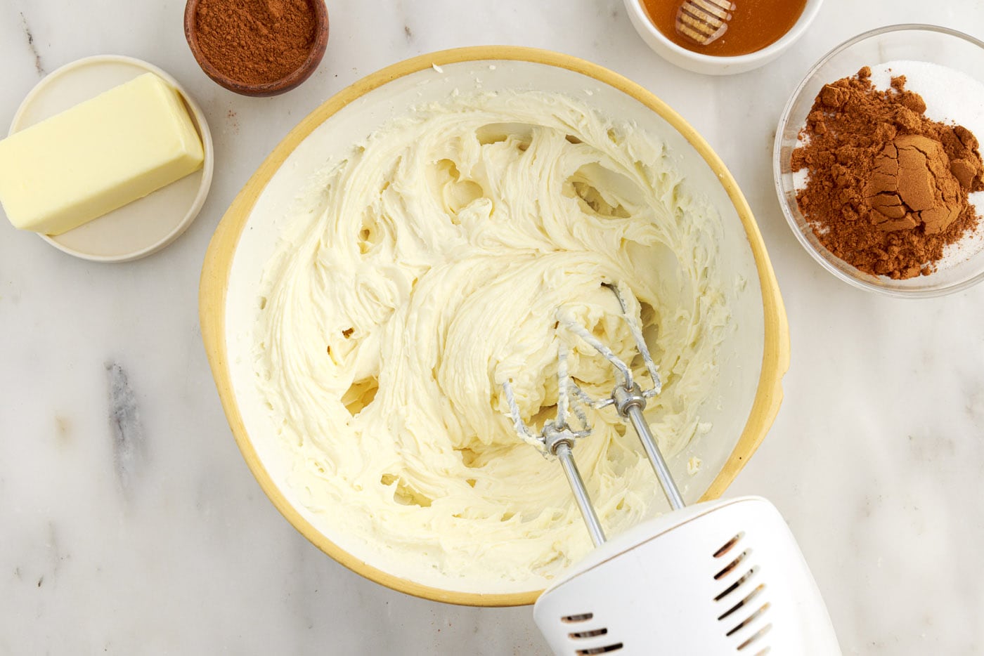 mixer combining cream cheese with vanilla and sugar