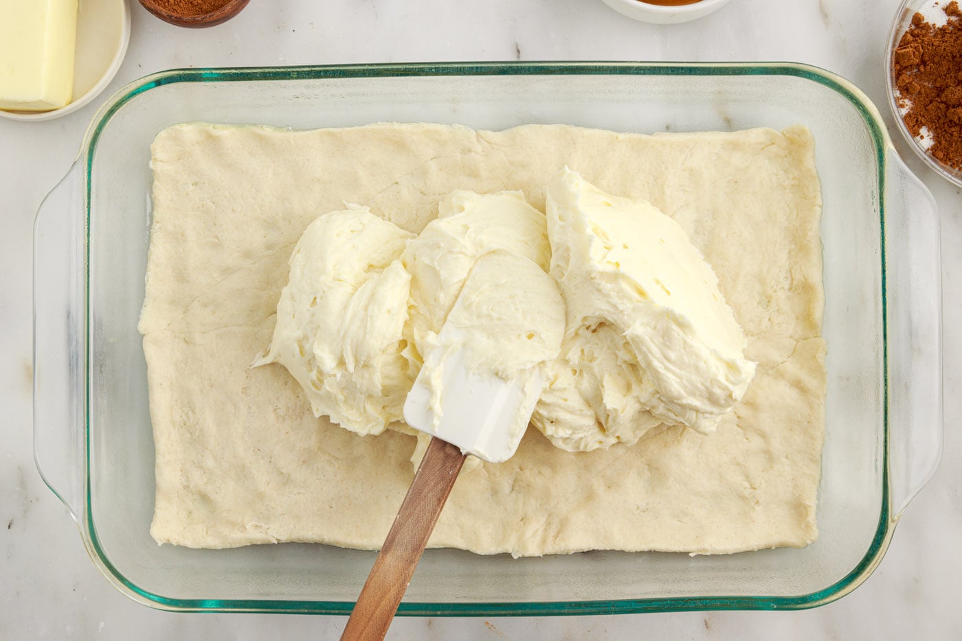 spreading cheesecake over crescent dough