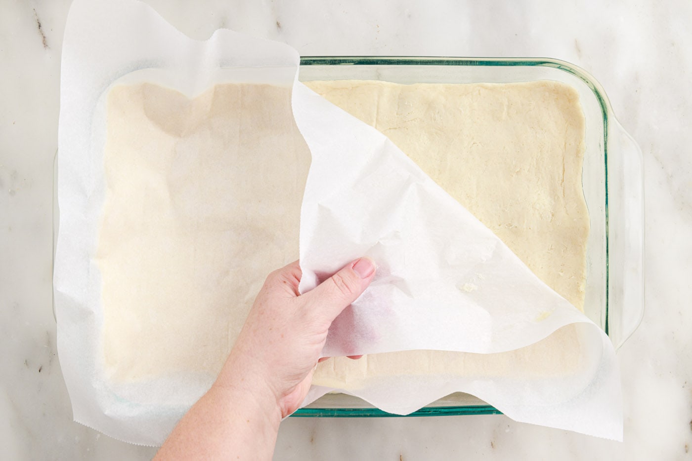 peeling parchment paper off the bottom of crescent dough