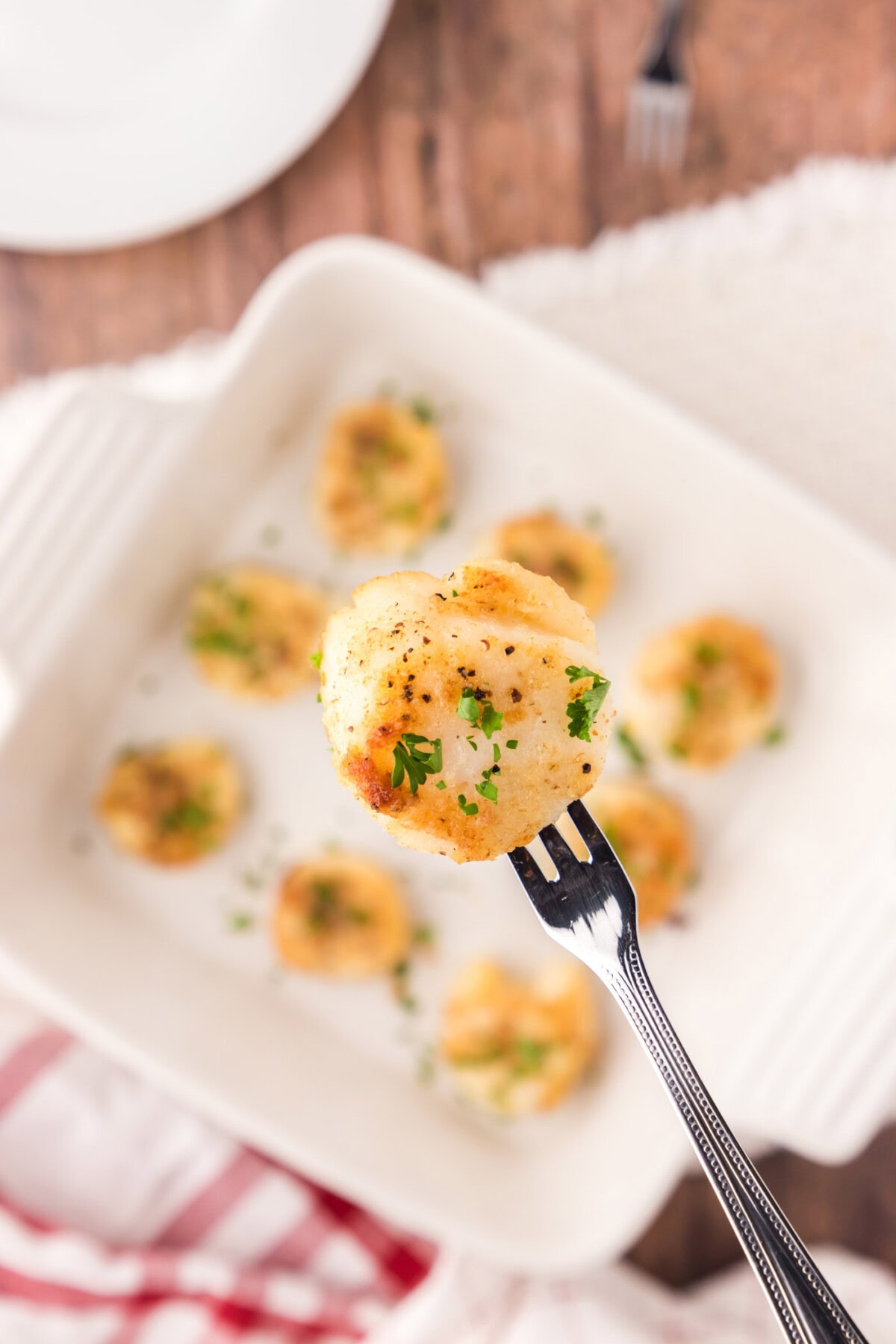 Close up of a Baked Scallop on a seafood fork