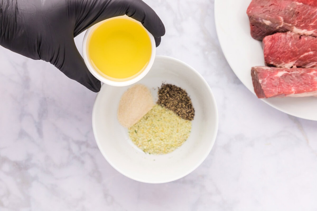 adding olive oil to salt, pepper, and onion powder