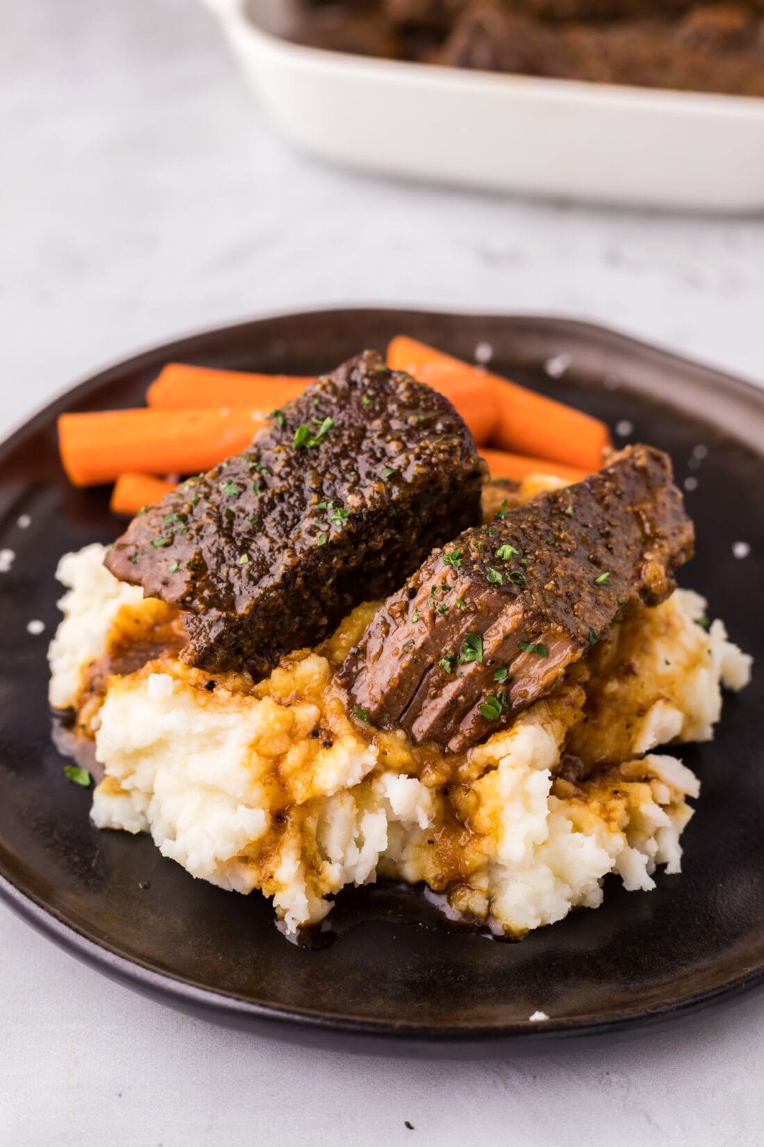 Boneless Beef Short Ribs served over mashed potatoes on a plate