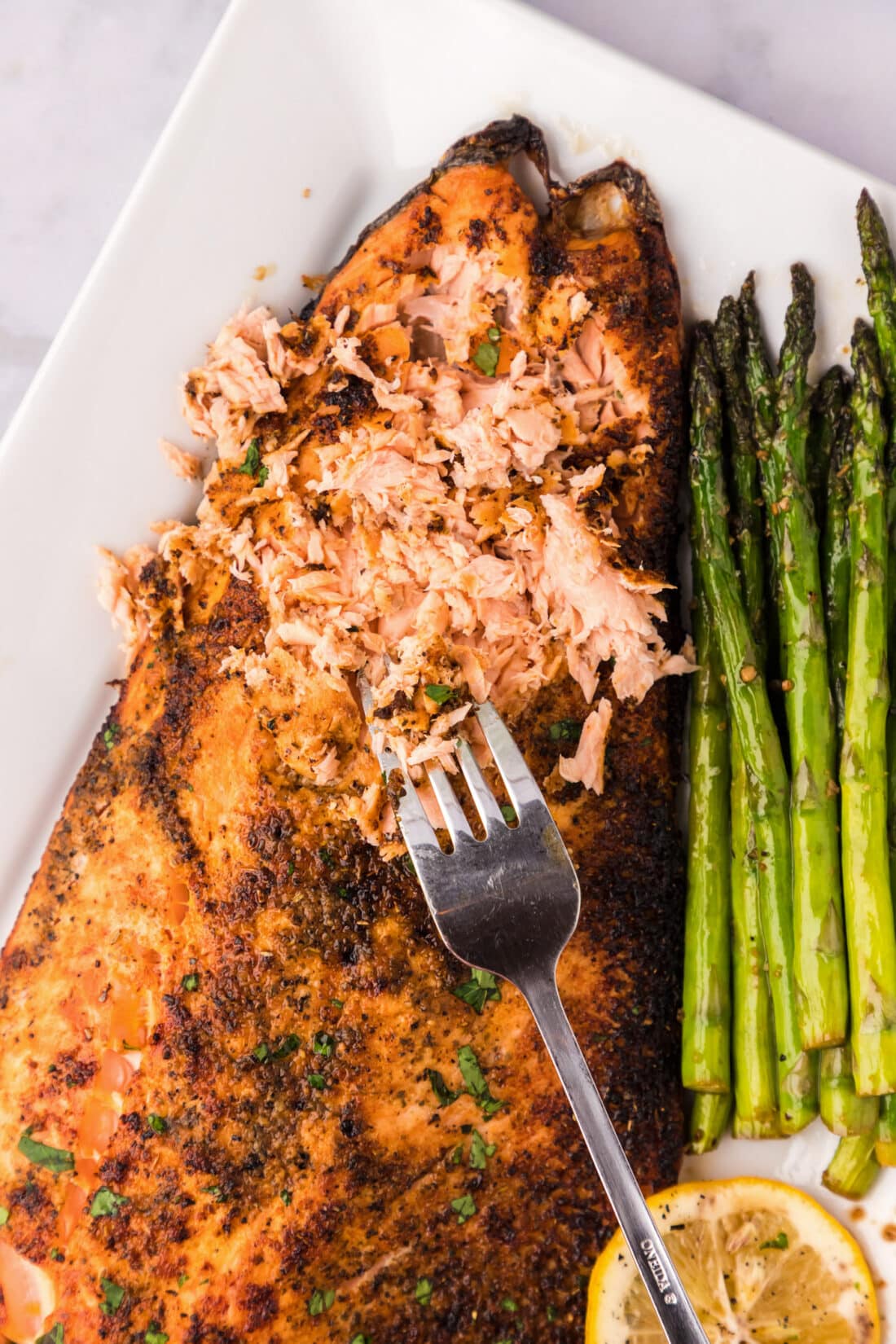 Close up photo of Broiled Salmon shredded by a fork