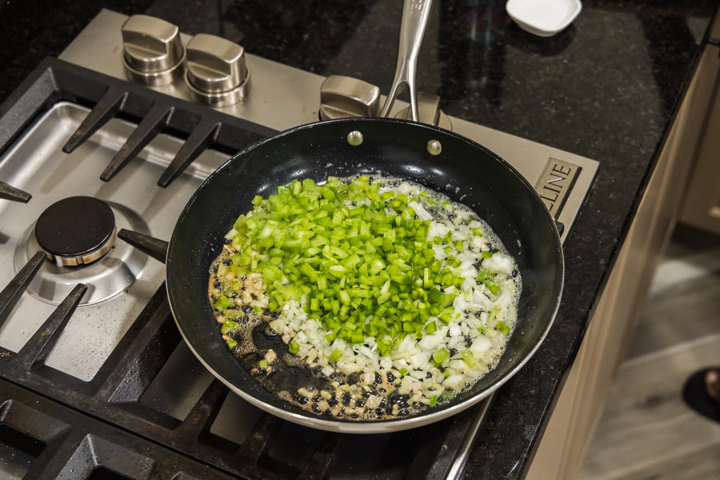 onion, green pepper, and celery in a skillet with butter