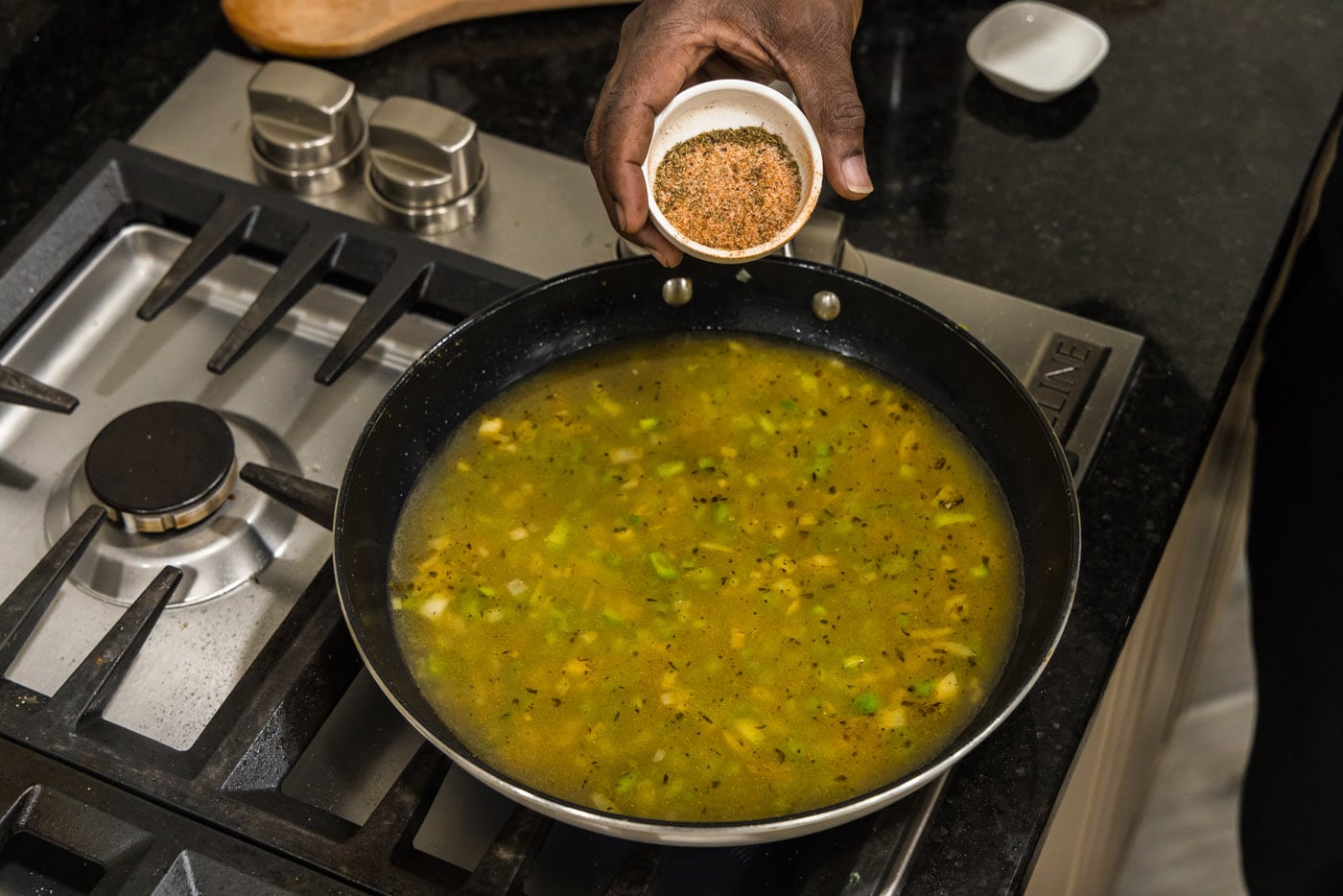adding remaining cajun seasoning to pan of vegetables