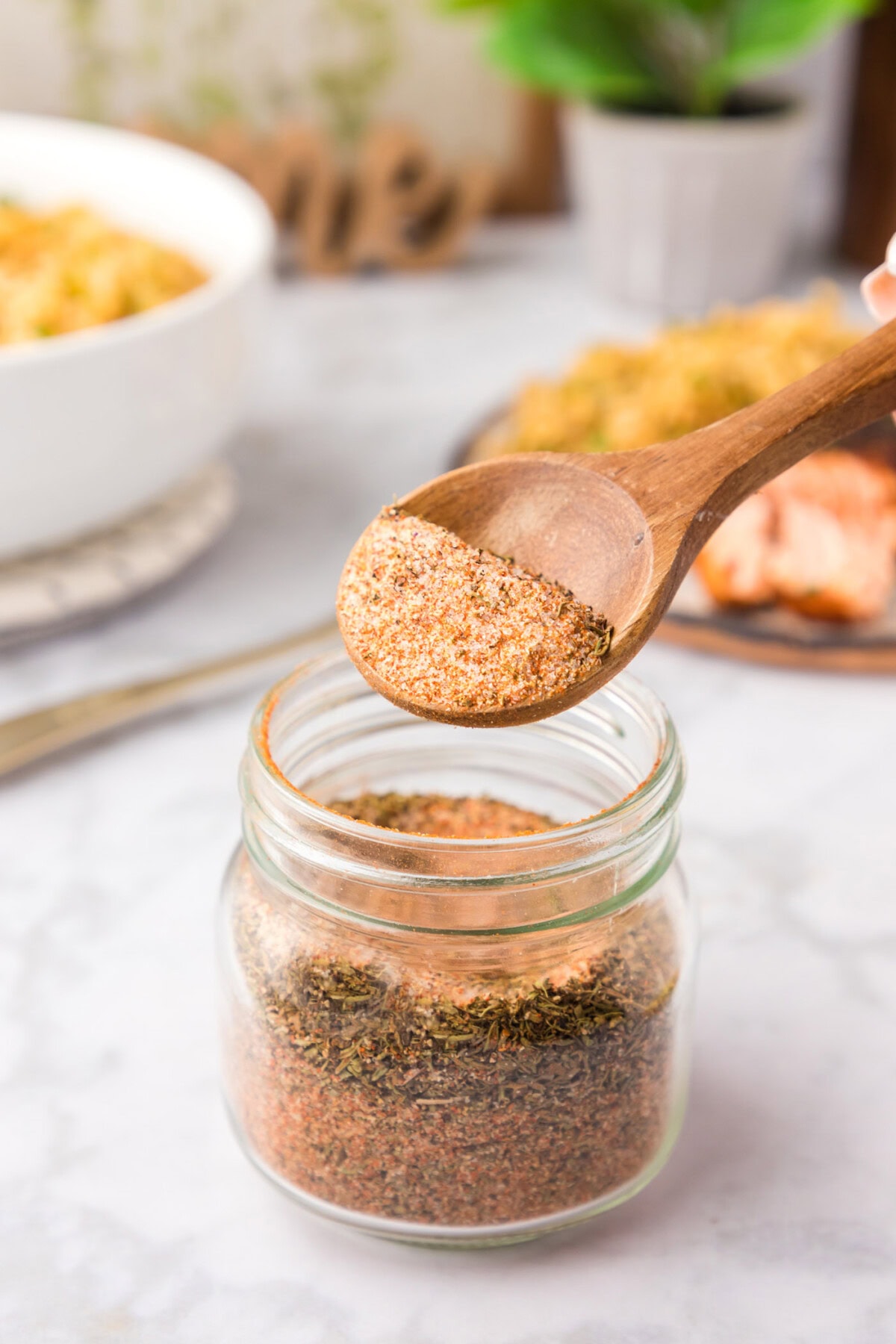 Spoonful of Cajun Seasoning being lifted out of a jar of Cajun Seasoning