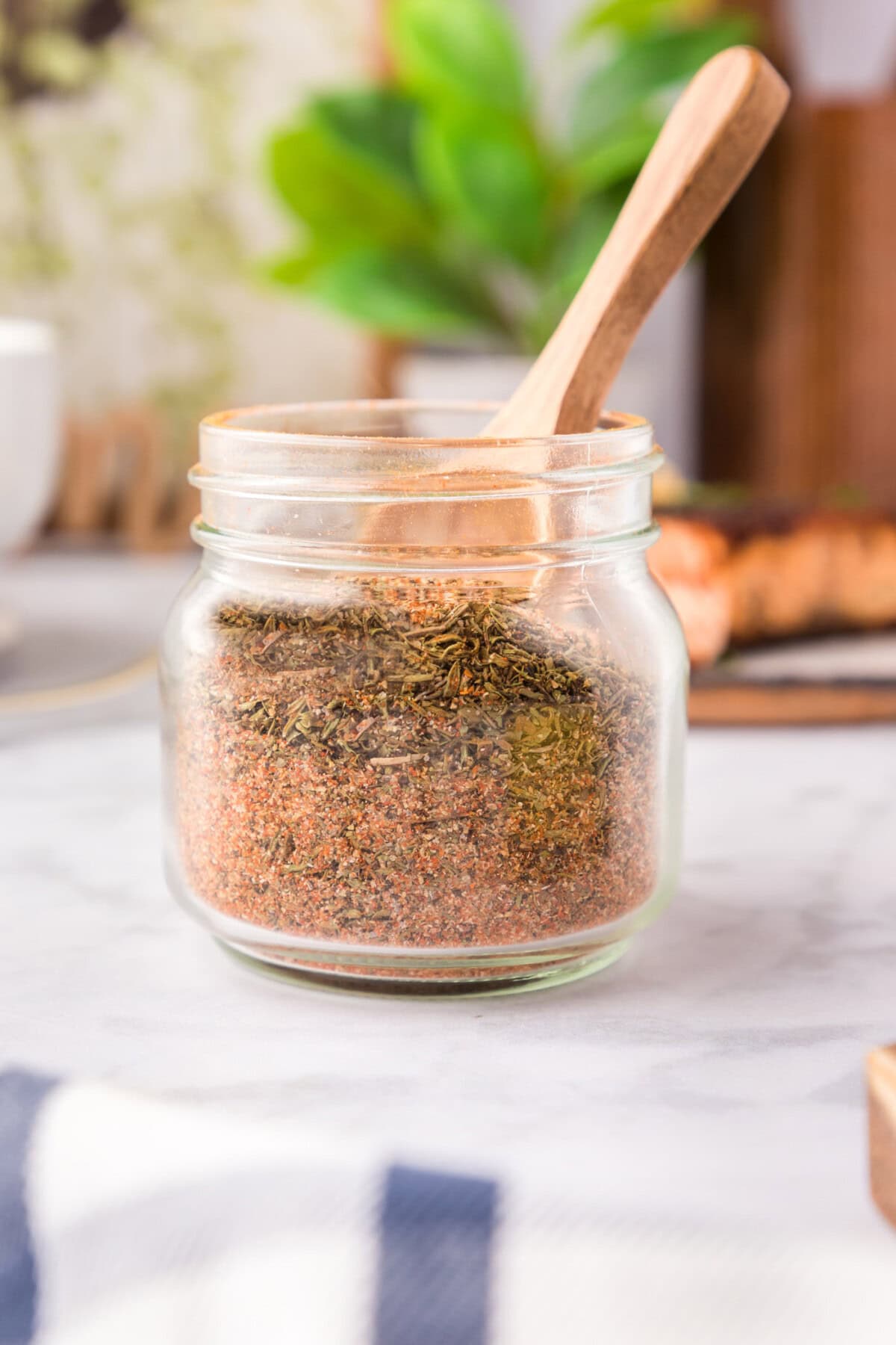 Jar of Cajun Seasoning with a wooden spoon in it