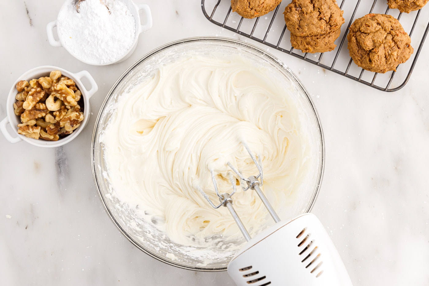homemade cream cheese frosting in a bowl with a mixer