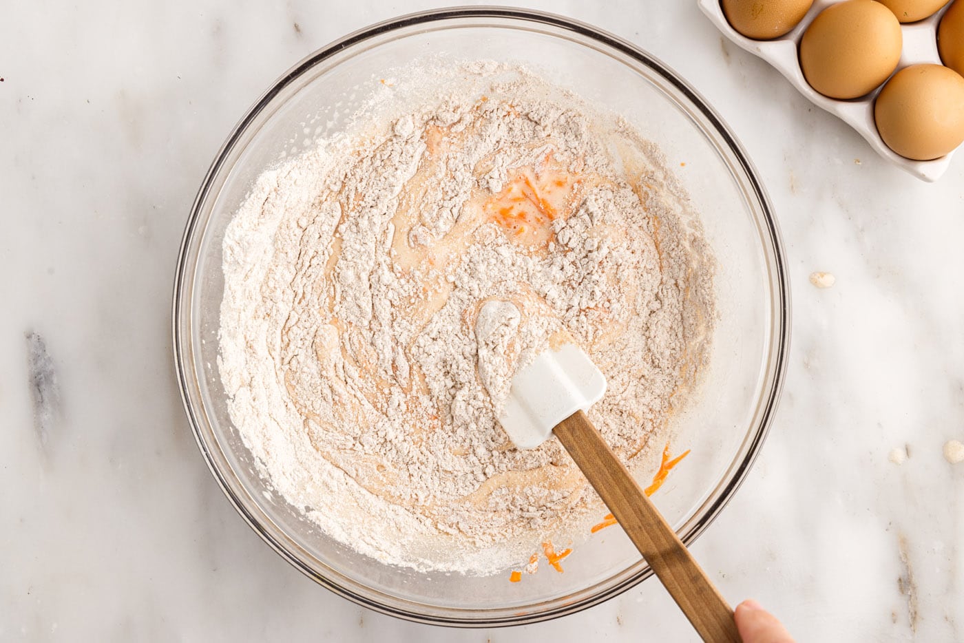 folding dry ingredients into wet ingredients for carrot cake