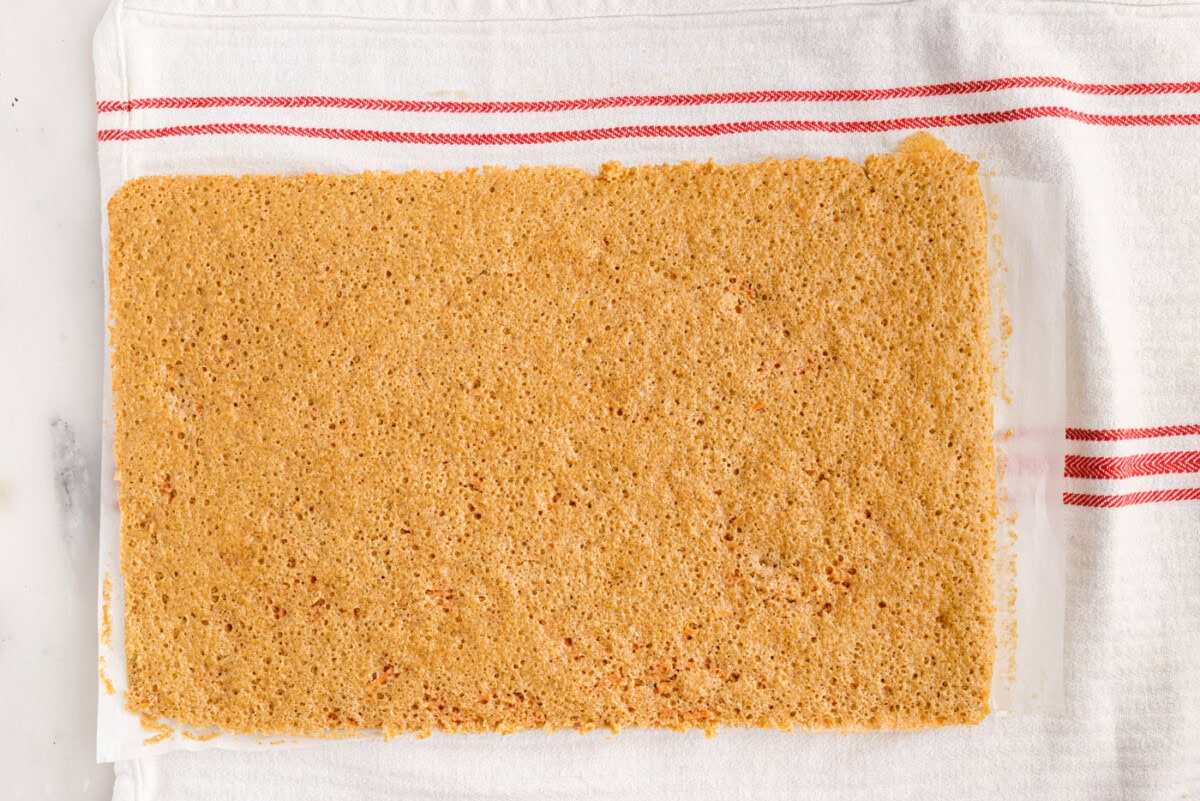 carrot cake on a tea towel dusted with powdered sugar