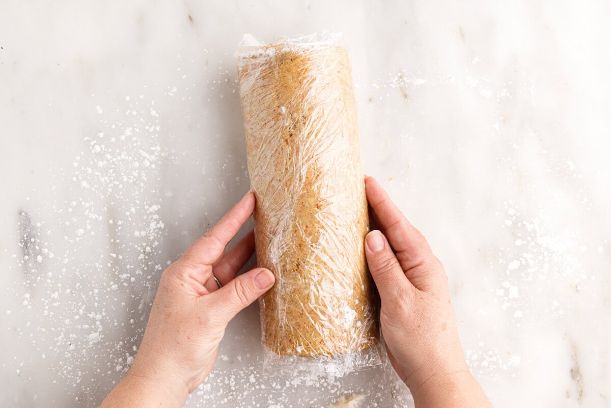 carrot cake roll secured with plastic wrap