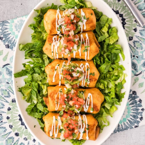 Chimichangas served over a bed of lettuce on a serving platter