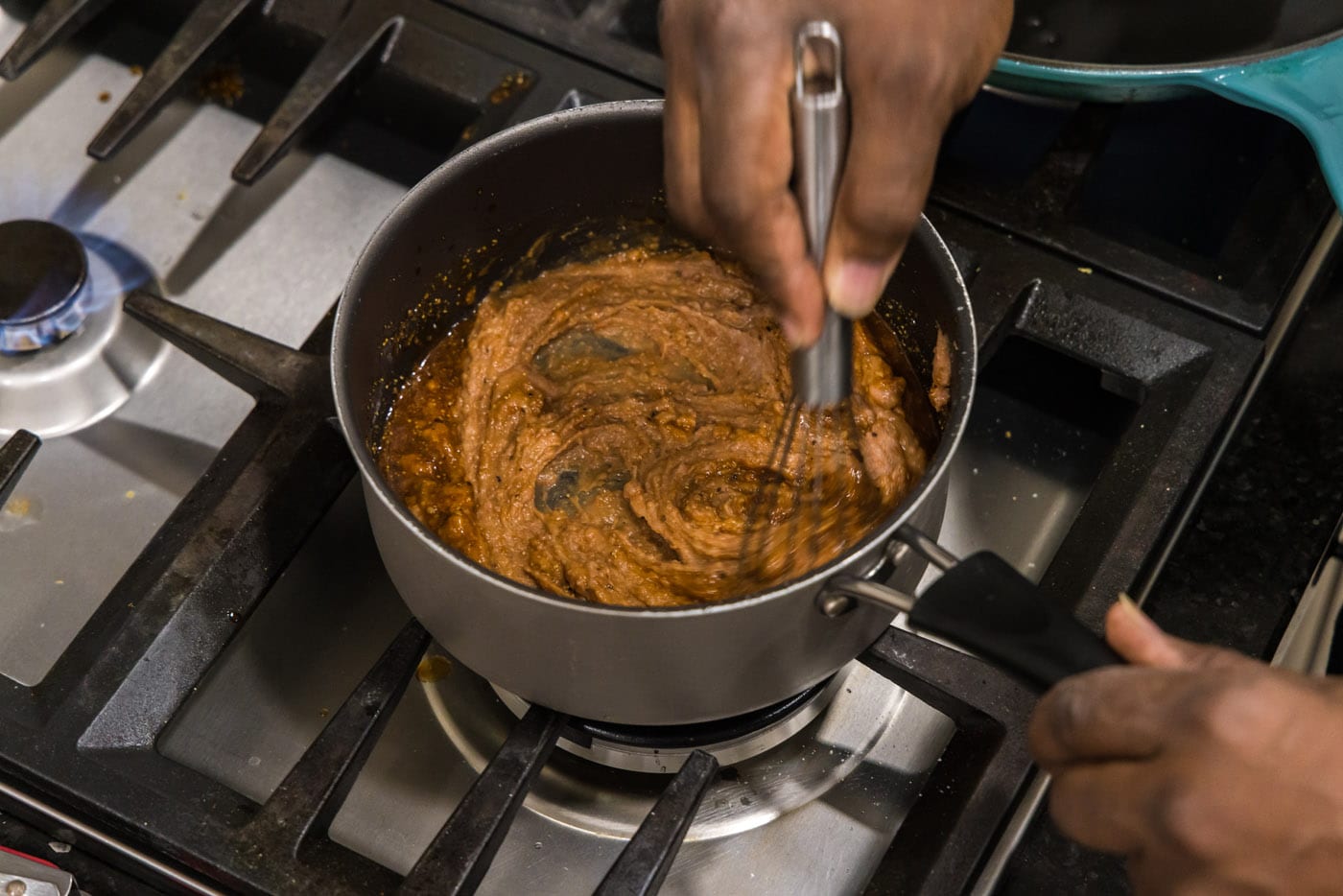 whisking refried beans in a pot