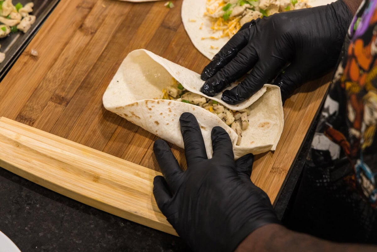 hands rolling a chimichanga